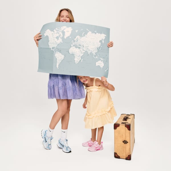 Famous Footwear brand two young girls wearing brand sneakers holding a map preparing for travel 