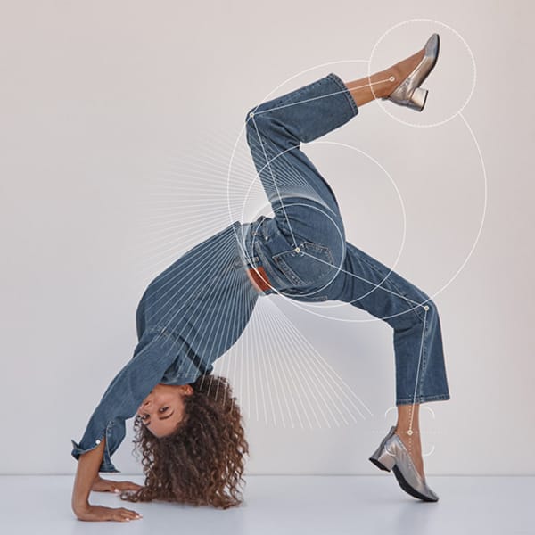 Vionic Brand woman in a backbend pose with right leg in the air wearing brand flats